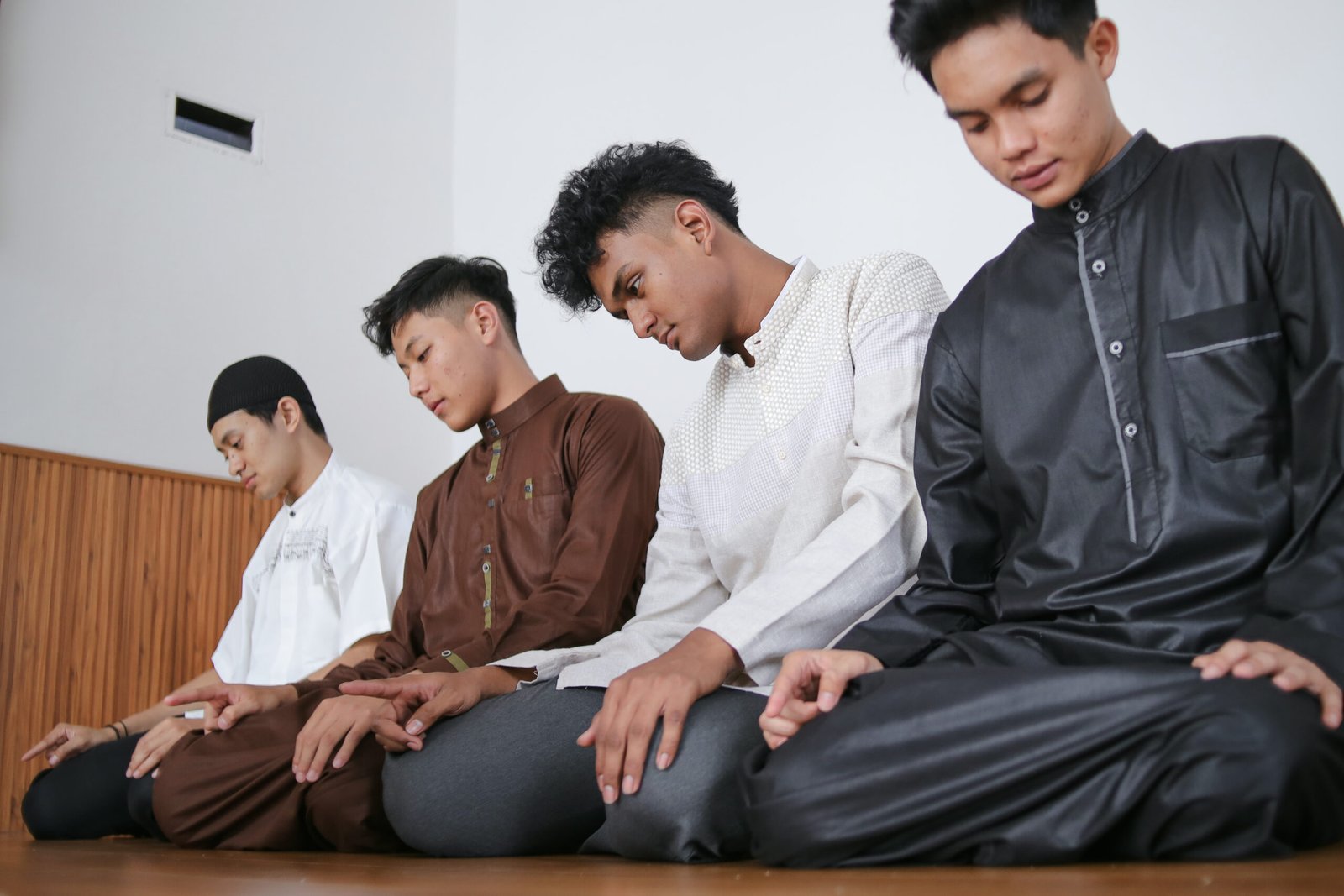 Muslim People In A Line On Sitting Position Performing Salah Together